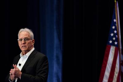 Chief Digital and Artificial Intelligence Officer Craig Martell walks across the stage at the Data and AI Symposium in Washington, D.C., during a Feb. 20, 2024, keynote speech.